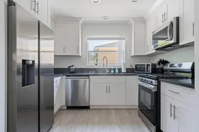 a kitchen with white cabinets and a stainless steel refrigerator at Serene Home in Central Burbank in Burbank