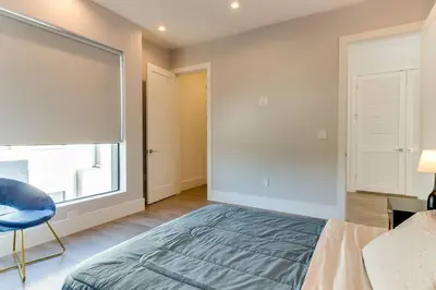 a bedroom with a bed and a window and a chair at Modern 4 Bedroom Masterpiece With Rooftop Deck in Los Angeles