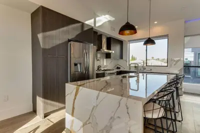 a kitchen with a marble counter top and a sink at Modern 4 Bedroom Masterpiece With Rooftop Deck in Los Angeles