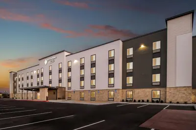 an empty parking lot in front of a building at WoodSpring Suites Palmdale - Lancaster in Palmdale