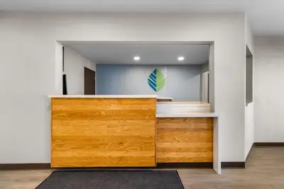 a room with a wooden cabinet and a staircase at WoodSpring Suites Palmdale - Lancaster in Palmdale