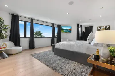 a bedroom with a large bed and a large window at Maravilla in Los Angeles
