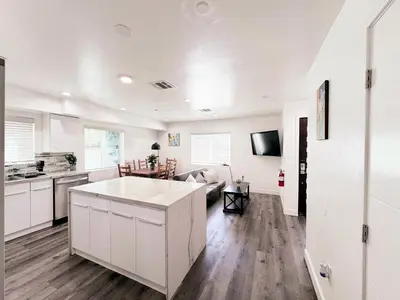 a kitchen and living room with white cabinets at Cozy 3 BR Townhouse with Balcony in Los Angeles