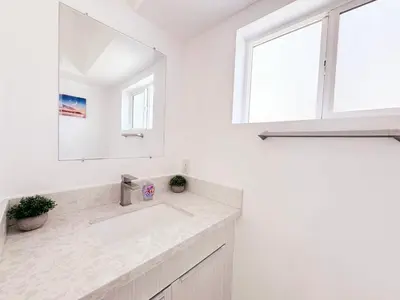 a white bathroom with a sink and a mirror at Cozy 3 BR Townhouse with Balcony in Los Angeles