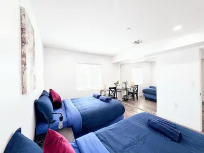a living room with two beds and a table at Cozy 3 BR Townhouse with Balcony in Los Angeles