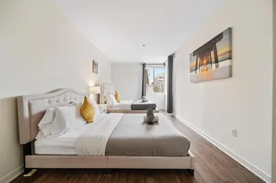 a white bedroom with a bed and a window at Le Reve , 5 min to the beach Luxury Condo in Los Angeles