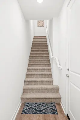 a staircase with white walls and a carpet at Luxurious Ontario Townhouse Ideal Family in Ontario