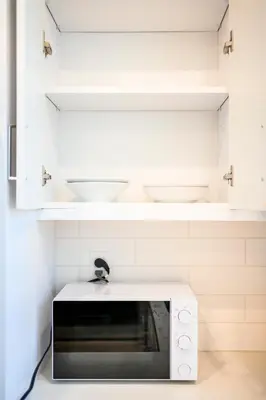 a microwave oven in a kitchen with white cabinets at Luxurious Ontario Townhouse Ideal Family in Ontario