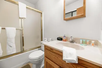 a bathroom with a sink and a toilet and a mirror at Silver Rays - Game room with pool table & air hockey! Close to the slopes!! in Big Bear Lake