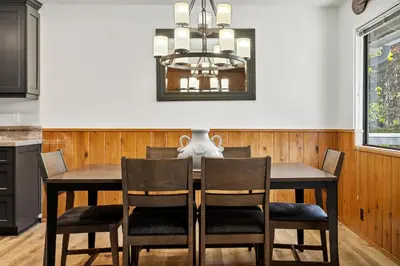 a dining room table with chairs and a chandelier at Pine Oaks Cabin in Lake Arrowhead