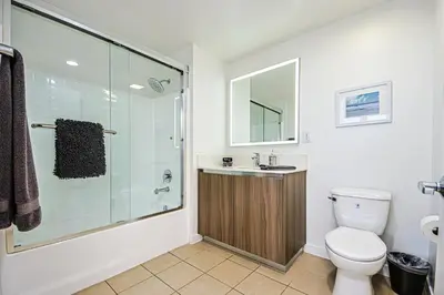 a bathroom with a shower and a toilet and a sink at The Carlton - Modern-Lux 2 Master Suites-Secure Bldg & Parking- 5 BLKS to Ocean Ave in Los Angeles
