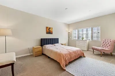 a bedroom with a bed and a chair at Charming 2BR2BA Home Near Downtown LA And Walkable Amenities in Monterey Park