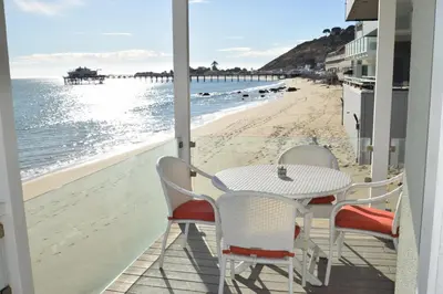 a table and chairs on a balcony with a view of the beach at Malibu Private Beach Apartments in Malibu