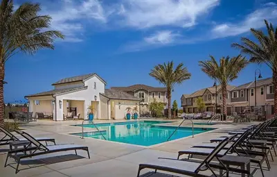 a swimming pool with chairs and palm trees at \u6d1b\u6749\u77f6\u5b89\u5927\u7565\u6e29\u6c34\u6cf3\u6c60\u4e09\u623f\u522b\u5885 in Ontario