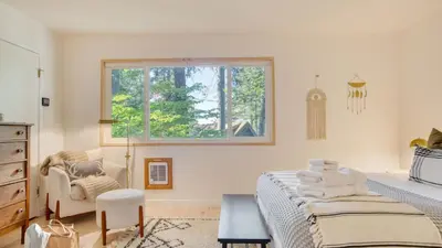a bedroom with a bed and a window and a chair at A-Frame Retreat Chic and Modern Forest Views Hammock Outdoor Dining Decks in Lake Arrowhead