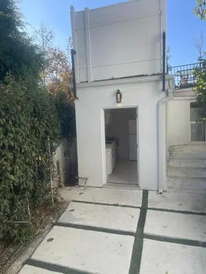 a white building with a door and stairs at UCLA Thurston in Los Angeles