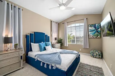 a bedroom with a blue bed and a window at Japanese Garden Yorba Linda Hills Luxury Home in Yorba Linda