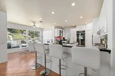 a kitchen with white cabinets and white bar stools at Japanese Garden Yorba Linda Hills Luxury Home in Yorba Linda