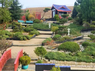 a garden with a red fence and some bushes at Japanese Garden Yorba Linda Hills Luxury Home in Yorba Linda