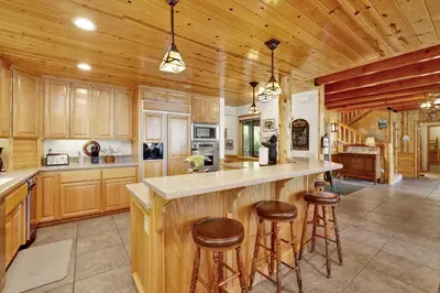 a kitchen with wooden cabinets and a large island with bar stools at Eagle point lake house #2471 in Big Bear Lake