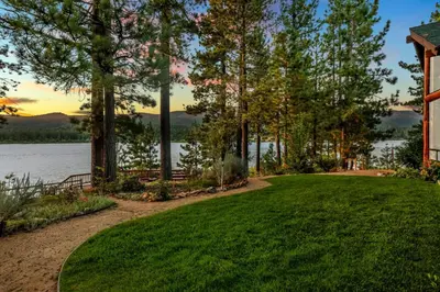 a lawn in front of a house with a view of the water at Eagle point lake house #2471 in Big Bear Lake