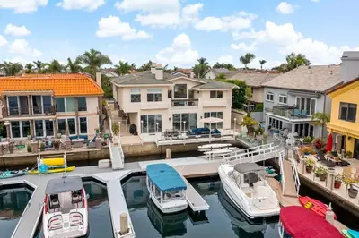 a group of boats docked at a marina with houses at Luxury Waterfront Home in the Heart of the Harbor in Huntington Beach