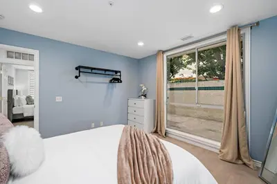 a bedroom with blue walls and a large window at Luxury Waterfront Home in the Heart of the Harbor in Huntington Beach