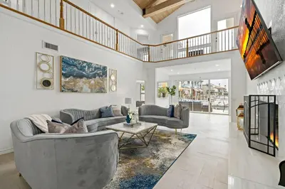 a living room with a couch and a table at Luxury Waterfront Home in the Heart of the Harbor in Huntington Beach