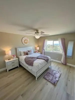 a bedroom with a bed and a ceiling fan at Top of the World Anaheim View Home in Anaheim
