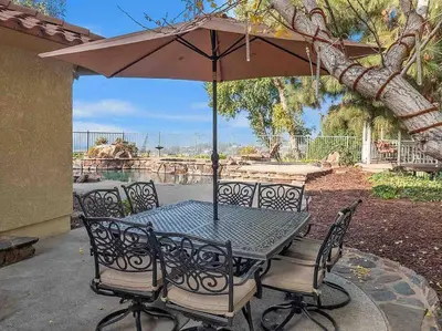 a table and chairs with an umbrella on a patio at Secluded Romantic Getaway Home in Anaheim
