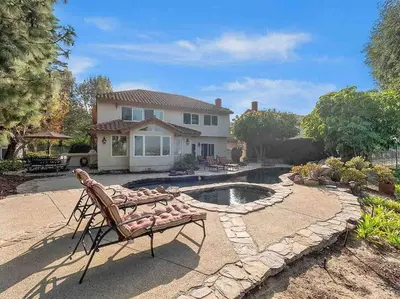 a house with a bench in front of a pool at Secluded Romantic Getaway Home in Anaheim