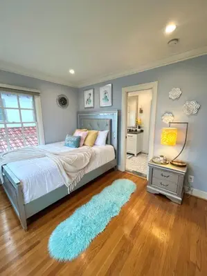 a bedroom with a bed and a blue rug at Ocean Boulevard Beachfront Home in Long Beach