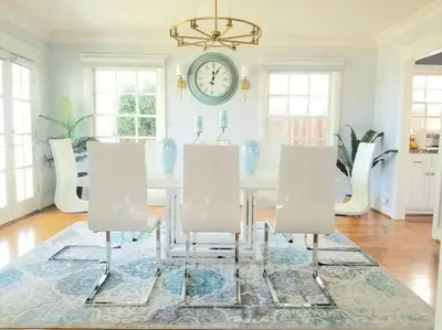 a dining room with a table and chairs and a clock at Ocean Boulevard Beachfront Home in Long Beach