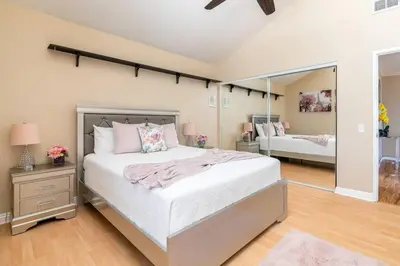 a bedroom with a large bed and a mirror at Majestic Anaheim Panorama Hill Home With Sunset in Anaheim