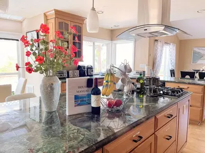 a kitchen with a counter with a vase with flowers on it at Majestic Anaheim Panorama Hill Home With Sunset in Anaheim