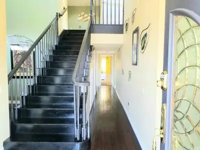 a hallway with black stairs in a house at Stunning Panoramic Waterfront Pool Home Escape in Anaheim