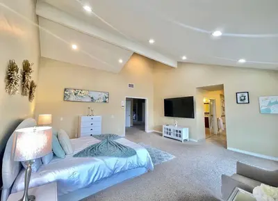 a bedroom with a bed and a flat screen tv at Stunning Panoramic Waterfront Pool Home Escape in Anaheim
