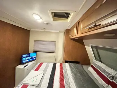 a small room with a bed and a tv at Rooms in Modern RV Trailer Home in Los Angeles