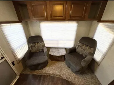 a living room with two chairs and a table and windows at Rooms in Modern RV Trailer Home in Los Angeles