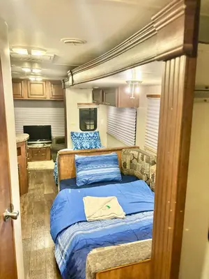 a bedroom with a bed with blue pillows in it at Rooms in Modern RV Trailer Home in Los Angeles