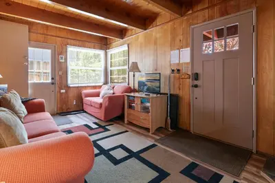 a living room with a pink couch and a door at Chateau Rouge - Walk to Lake & Village, AC, Pet Friendly! in Big Bear Lake