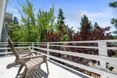 two wooden benches sitting on a white fence at Chateau Rouge - Walk to Lake & Village, AC, Pet Friendly! in Big Bear Lake