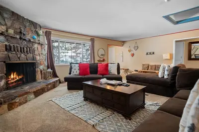 a living room with a couch and a fireplace at Wanderlust - Hot Tub, Foosball, Ping Pong, Walk to Lake & Village! in Big Bear Lake