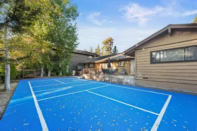 a tennis court in front of a house at Wanderlust - Hot Tub, Foosball, Ping Pong, Walk to Lake & Village! in Big Bear Lake