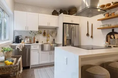 a kitchen with white cabinets and a sink and a counter at Zen Birds Nest of Topanga Boho Chic with Epic Deck in Topanga