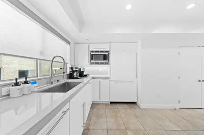 a white kitchen with white cabinets and a sink at The Diamond Dune - Upscale 3 Level 4BR Terrace Santa Monica in Los Angeles