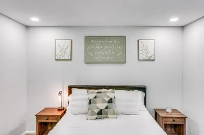 a bedroom with a bed with two wooden tables at 1 Mi to Lake Crestline Cabin with Deck and Gas Grill! in Crestline