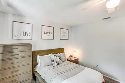 a bedroom with a bed and three pictures on the wall at 1 Mi to Lake Crestline Cabin with Deck and Gas Grill! in Crestline