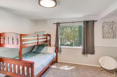 a bedroom with two bunk beds and a window at 1 Mi to Lake Crestline Cabin with Deck and Gas Grill! in Crestline