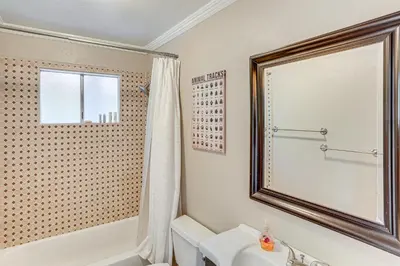 a bathroom with a tub and a sink and a mirror at 1 Mi to Lake Crestline Cabin with Deck and Gas Grill! in Crestline
